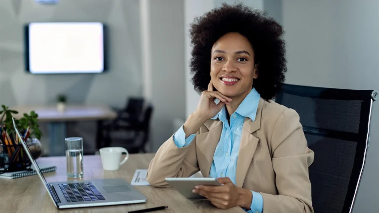 happy African American businesswoman working on a touchpad and laptop at the creative media